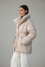 Model draagt beige puffer winterjas zijkant